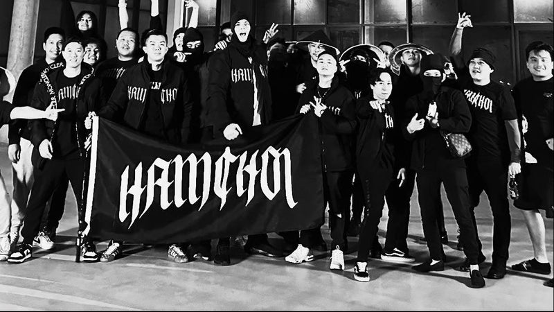 Group of people posing with a banner inside a building